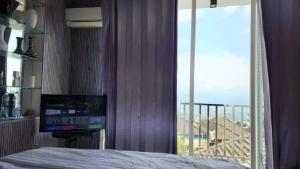 バトゥにあるVilla kusuma pinus M-59のベッドルーム1室(ベッド1台付)、窓、バルコニーが備わります。