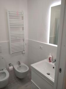 a white bathroom with a sink and a toilet at Trilocale San Vincenzo in San Vincenzo +6 photos