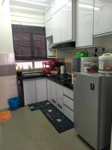 a kitchen with white cabinets and a refrigerator at Aisy Homestay in Kuala Terengganu