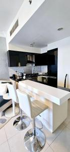 a kitchen with a white counter and white chairs at Superb 1 BR apt next to Burj Khalifa and Dubai mall in Dubai