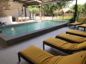 a swimming pool with two chaise lounges next to at Le Mas Daniélou - 4 étoiles - Climatisé in Chandolas