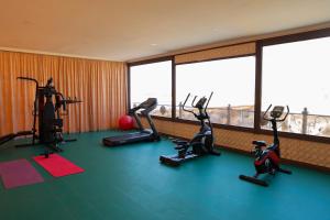 un gimnasio con bicicletas estáticas en una sala con ventanas en Said Islom Khoja, en Khiva