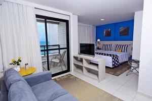 a living room with a couch and a bedroom at Comfort Hotel & Suites Natal in Natal