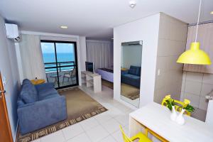 a living room with a blue couch and a balcony at Comfort Hotel & Suites Natal in Natal