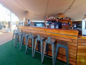 a bar with a row of stools in front of it at Acorn Lodge & SKYDECK in Potchefstroom