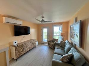 a living room with a couch and a flat screen tv at Sunflower 3 in St. George Island