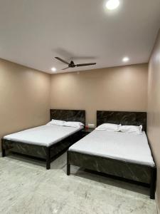 2 letti in una camera con soffitto di Crystal Inn a Salkhia
