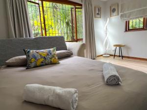 a bed with two towels on it in a bedroom at Spacious George self catering apartment for families, golfers, business travellers and couples 1 queen bed 2 sleeper couches in George