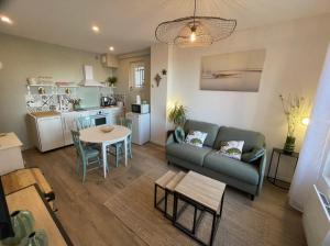a living room with a couch and a table at L'étoile, Appartement 1 chambre, vue mer- rénové et cosy- tout inclus in Ault