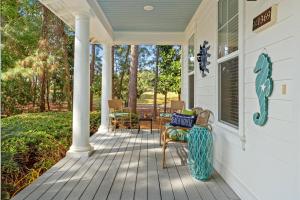 a porch with a bench and chairs on a house at 1369 Laurel Grove "The Crows Nest" in Destin