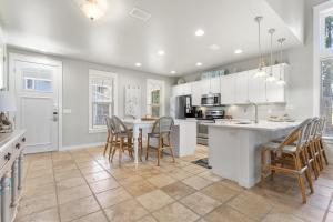 a kitchen with white cabinets and a table and chairs at 1369 Laurel Grove "The Crows Nest" in Destin