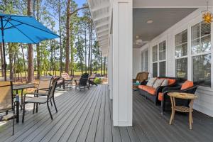 a porch with a couch and tables and chairs at 1369 Laurel Grove "The Crows Nest" in Destin