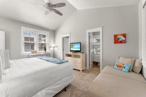 a bedroom with two beds and a tv and a couch at 1369 Laurel Grove "The Crows Nest" in Destin