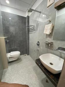 カーンプルにあるHotel Liyan Innの白い洗面台とトイレのあるバスルーム +19枚の写真