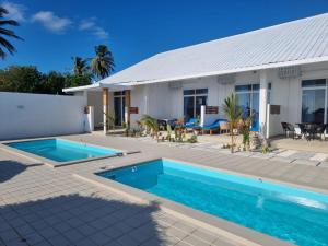 a house with a swimming pool in front of it at True South in Maradhoofeydhoo