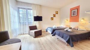 a hotel room with two beds and a chair at VILLA CASSIA w Rabce przy Parku Zdrojowym - smaczne śniadania i obiady in Rabka-Zdrój