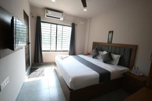 ein Schlafzimmer mit großem Bett und Fenster in der Unterkunft Hotel StayInn in Kozhikode