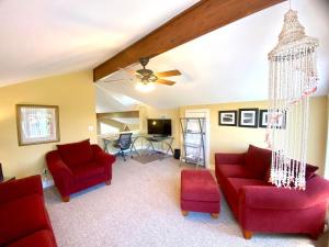 a living room with two red chairs and a ceiling fan at Somehow, Someday, Somewhere, Seaside in St. George Island