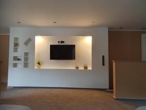 a white wall with a flat screen tv on a wall at Burgberg in Altena