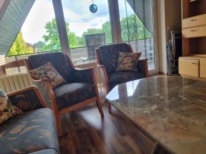 a living room with two chairs and a glass table at Ferienwohnung Looser Patt in Tecklenburg in Tecklenburg +9 photos