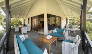 a patio with blue couches and a table and chairs at Vrijstaande BB BEACH Villa Azure in Blue Bay