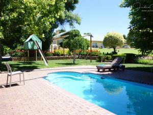 a pool with a slide and a bench and a playground at Mieliefontein Karoo Guest Farm in Hanover Road