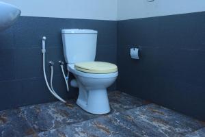 - une salle de bains avec des toilettes blanches dans une cabine dans l'établissement Pepper Garden Cottage, à Uda Walawe