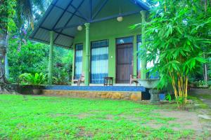 une serre avec un banc et un parasol dans l'établissement Pepper Garden Cottage, à Uda Walawe