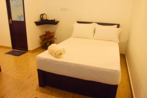 une chambre avec un grand lit avec des draps blancs dans l'établissement Pepper Garden Cottage, à Uda Walawe