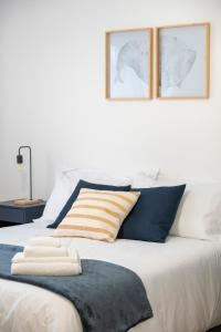 a bed with blue and white pillows on it at Residenza JOY in Pordenone