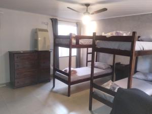 阿拉亚尔-杜卡布Casa Airport的带三张双层床和梳妆台的客房