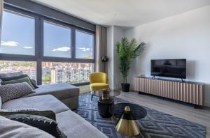 a living room with a couch and a tv at ANSA Beach Apartments - Malaga - Skyline Suite in Málaga