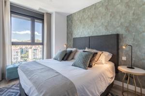 a bedroom with a large bed with a large window at ANSA Beach Apartments - Malaga - Skyline Suite in Málaga +27 photos