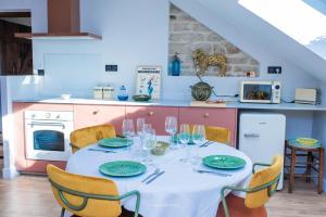 a kitchen with a table with a white table cloth and chairs at La Maison Laborey - Gîte de la Combe in Dijon