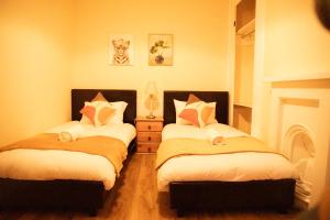 a bedroom with two beds and a fireplace at Gloucester Haven Retreat in Gloucester