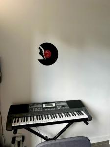 un teclado negro y un disco de vinilo en una pared en Appartement Business Lyon nord Gare & A6, en Saint-Germain-au-Mont-dʼOr