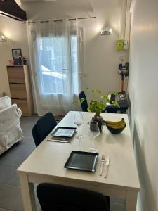 Una mesa blanca con dos copas de vino. en Appartement Business Lyon nord Gare & A6, en Saint-Germain-au-Mont-dʼOr