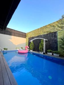 uma piscina com um flamingo rosa na água em Griya Ngasem Djogja em Yogyakarta