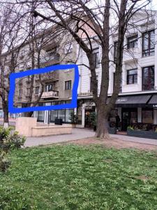 a picture of a building in front of a tree at Apartament ANNA in Carei