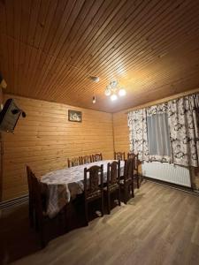 a dining room with a table and chairs at "Гірська Домівка" КОТЕДЖ з Чаном-Джакузі та басейном in Volosyanka +17 photos