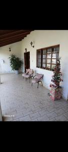 eine Terrasse mit zwei Bänken und einem Weihnachtsbaum in der Unterkunft Casa em carragua in Caraguatatuba