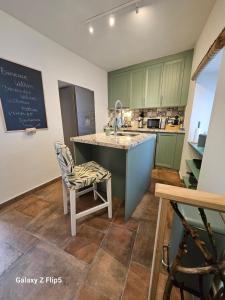 a kitchen with green cabinets and a counter with a sink at Olé Toledo in Cómpeta
