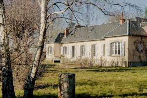 an old white house with a gray roof at La Ronce in Châteauneuf-sur-Loire
