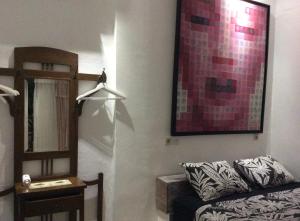 a living room with a couch and a painting on the wall at The Patio Yogya in Yogyakarta