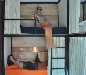 two girls are sitting on top of bunk beds at The Patio Yogya in Yogyakarta