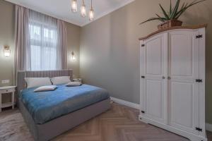 een slaapkamer met een bed en een grote witte kast bij Olive Apartment 1 - w Free Parking, self-checkin, 5 min from Aquapark Nymphaea in Oradea