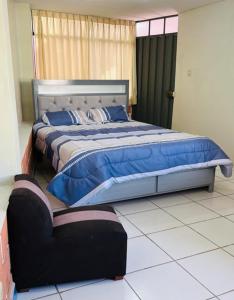 a bedroom with a large bed with blue pillows at Fresia's House in Tacna