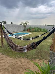 a hammock in a yard next to a pool at Cantinho da Rasa in Cabo Frio