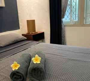 a bed with green towels and yellow flowers on it at The Patio Yogya in Yogyakarta
