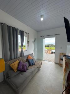 a living room with a couch with pillows on it at Cantinho da Rasa in Cabo Frio